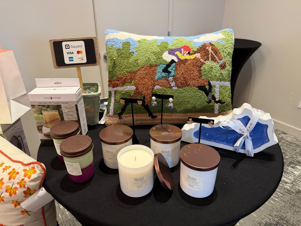 High Spirits soy candles, layered jars, and seasonal décor arranged on a market table